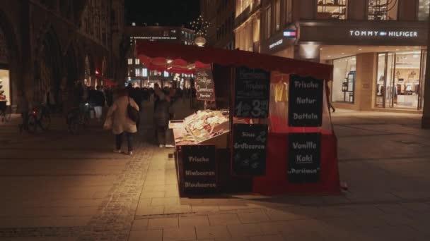 Мюнхен (Німеччина) - 26 листопада 2019 року: У реальному часі люди, які проїжджали повз каюту з їжею на вулиці в Мюнхені увечері, Німеччина.. — стокове відео