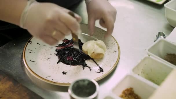 Close up of chef lying three profiteroles on a plate — Stock Video