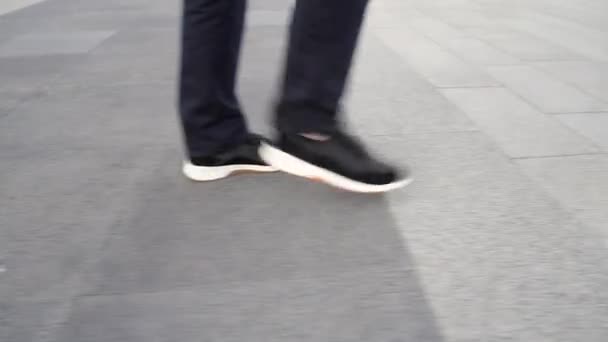 Profilo vista da terra degli uomini in sneakers grigie che camminano lungo il marciapiede — Video Stock