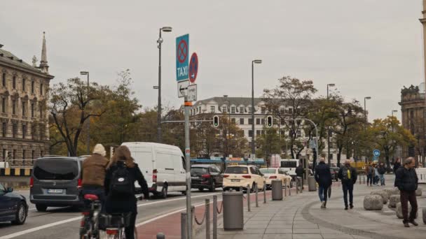 München, Tyskland - 27 november 2019: Låst realtidsbild av människor som går på trottoaren. Trafiken i München, Tyskland — Stockvideo
