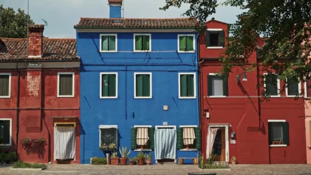 En tiempo real el establecimiento de tiro de una calle con casas de colores en la isla de Burano en Italia. Burano es famoso por sus coloridas casas . — Vídeo de stock