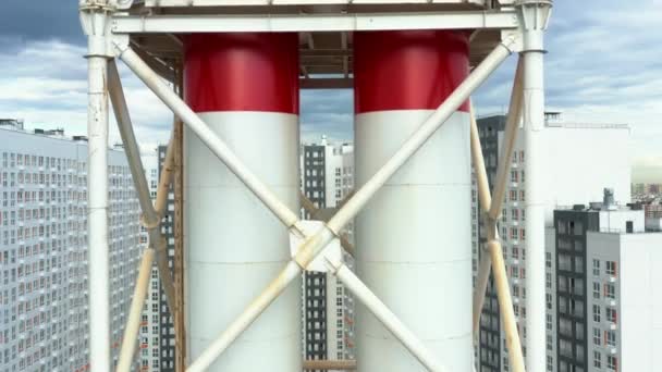 Tubo de fábrica vermelho e branco de uma fábrica de perto, drone aéreo voando para cima tiro — Vídeo de Stock