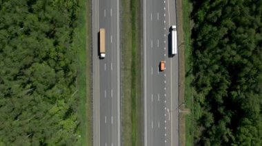 Çevresi yeşil ağaçlarla çevrili çok şeritli yollar, bir otoban insansız hava aracının üzerinden uçar.