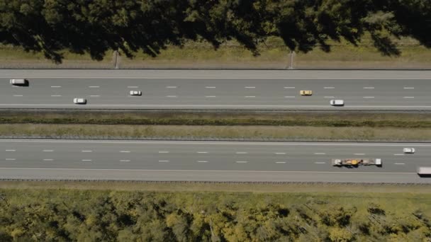 녹색 나무에 둘러쌓인 다중 차선 도로, 고속도로 드론 공중 촬영을 확대 — 비디오