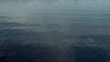 Gölün yüzeyinde küçük dalgalar, mavi su dokusunun drone görüntüsü.