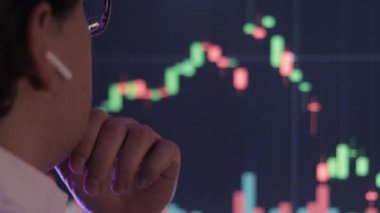 İşadamı bilgisayardaki borsa grafiğini analiz ediyor.