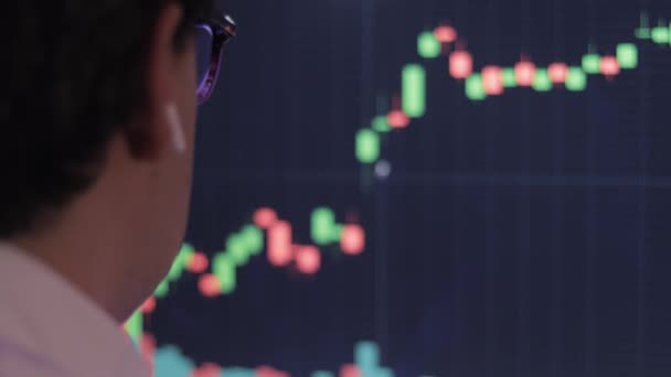 コンピュータ上の証券取引所チャートのグラフィックを分析するビジネスマン — ストック動画