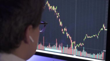 İşadamı bilgisayardaki borsa grafiğini analiz ediyor.