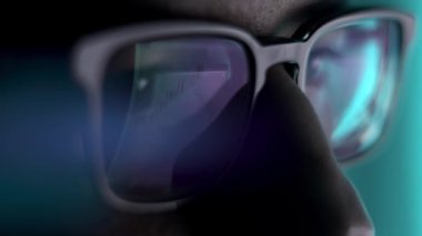 Gece geç saatte gözlüklü bir adam dizüstü bilgisayarın önünde...