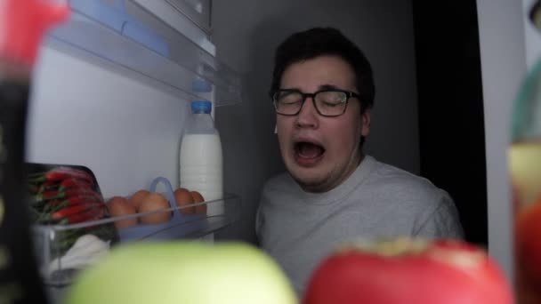Az ember kora reggel kinyitja a hűtőt, almát vesz be. — Stock videók