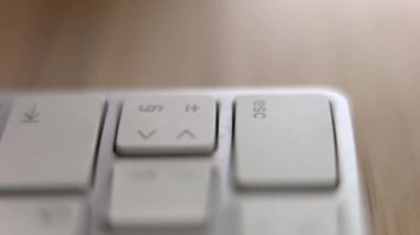 Beyaz klavyede ESC tuşuna basan bir parmak.