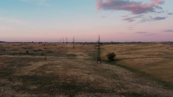 Drone d'un vaste champ sous un ciel nuageux au coucher du soleil — Video