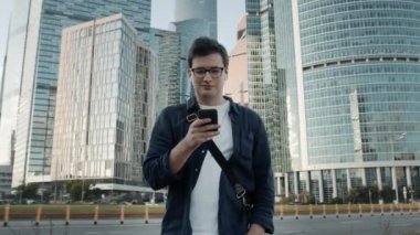 Moskova 'da elinde telefonla yürüyen genç adam, ağır çekimde.