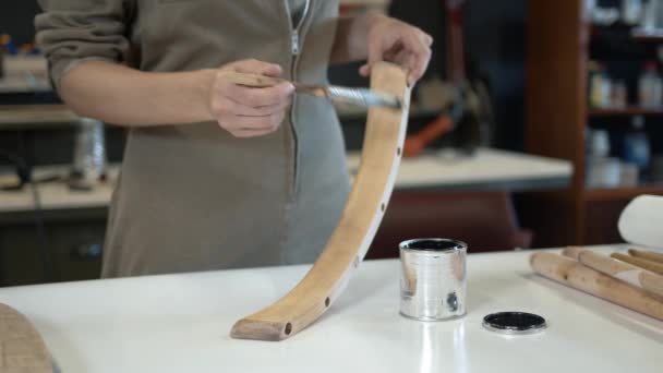 Kvinna målning en trästol ben i en verkstad, restaureringsprocess — Stockvideo