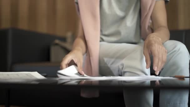 Mains féminines triant les blancs, les papiers, les documents assis sur un canapé — Video