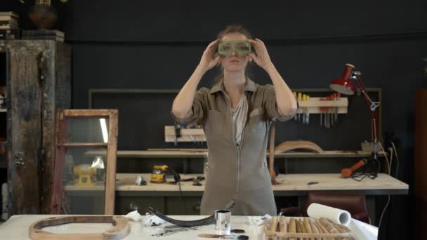 Donna che indossa occhiali di sicurezza in officina, lavori di restauro — Video Stock