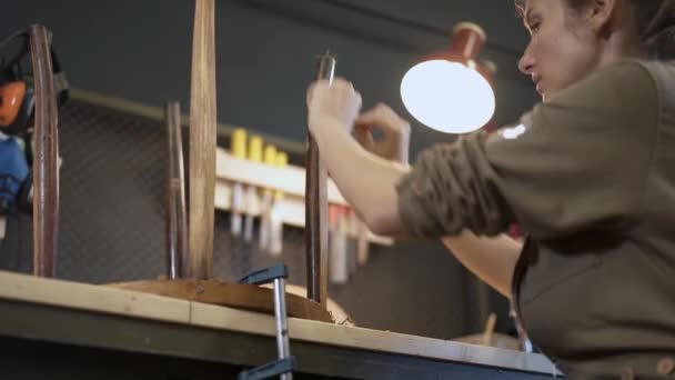 Restauración de la silla de madera en un taller, restaurador femenino — Vídeos de Stock