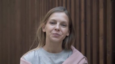 Ahşap çitin arkasında gülümseyen genç kadın, portreyi kapat.