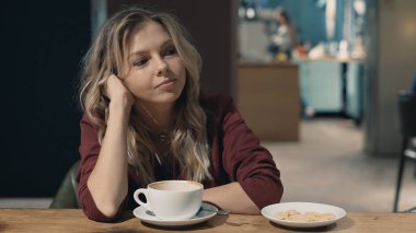 Kafedeki çekici, gülümseyen kadın rüya görüyor ve toplantı bekliyor.