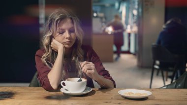Kafede internete girip akıllı telefon kullanan ve arkadaşlarıyla buluşmayı bekleyen çekici bir kadın. İşaret fişeği