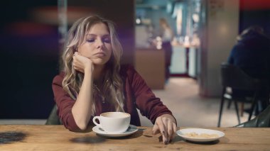 Kafede internete girip akıllı telefon kullanan ve arkadaşlarıyla buluşmayı bekleyen çekici bir kadın. İşaret fişeği