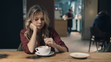 Kafede internete girip akıllı telefon kullanan ve arkadaşlarıyla buluşmayı bekleyen çekici bir kadın. İşaret fişeği