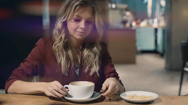 Atractiva mujer sonriente en la cafetería soñando y esperando una reunión. Bengala de lente — Foto de Stock