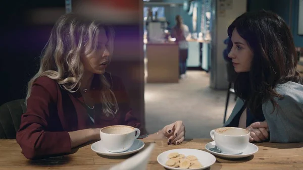 Két vonzó nő beszélgetett a kávézóban, és pletykákról beszélgettek. A barátság és a feminizmus fogalma. Lencsetűz — Stock Fotó