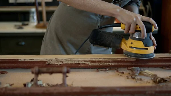 Жіночі руки шліфують дерев'яні двері, реставраційні роботи — стокове фото