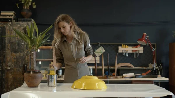 Egy női restaurátor sárga részletet fest a műhelyben — Stock Fotó