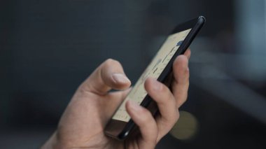 Sol el ve telefon bulanık arkaplanda telefonu kaydırıyor.