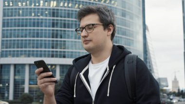 İş merkezinin arka planında telefonu olan bir adam.