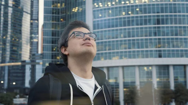 Uomo sorridente guardando gli edifici del centro business, testa buttata indietro — Foto Stock