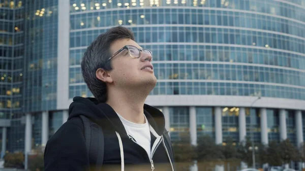 Homem sorrindo tiro perfil olhando para edifícios do centro de negócios — Fotografia de Stock