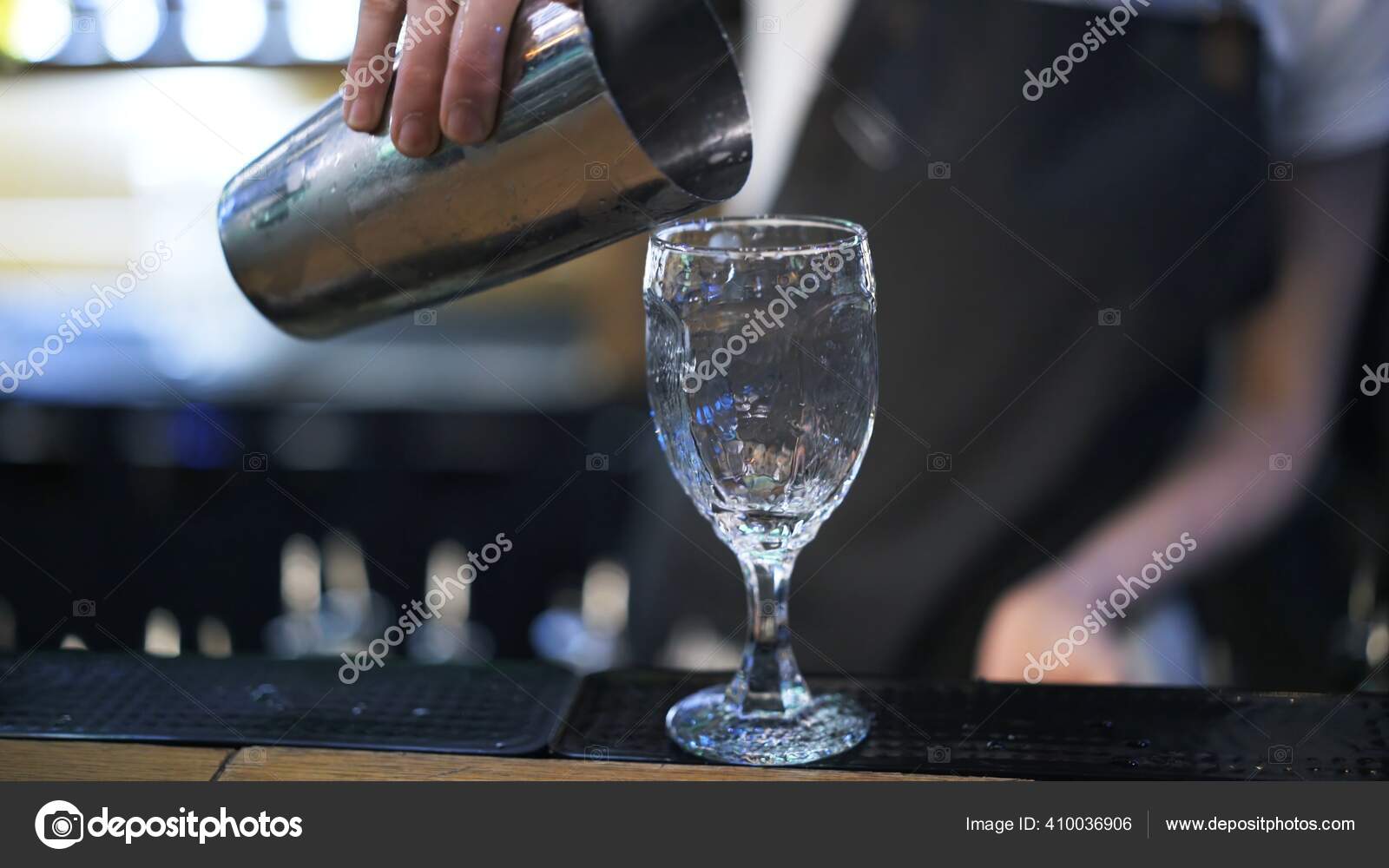 Bartender holding metal cup to pour cocktail into a glass Stock Photo by  ©DIProduction 410036906