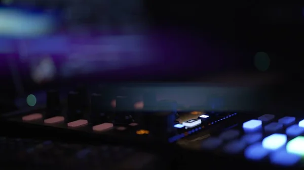 Fingers on music controller in night club, dark shot lens flare — Stock Photo, Image