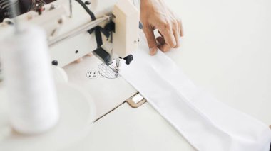 Beyaz dikiş makinesinin üstündeki kadın elleri, en iyi görüntü.