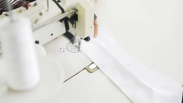 Pice of white cloth on white sewing machine, top view shot — Stock Photo, Image