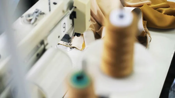 Bobinas de hilo borrosas sobre el fondo de la máquina de coser — Foto de Stock