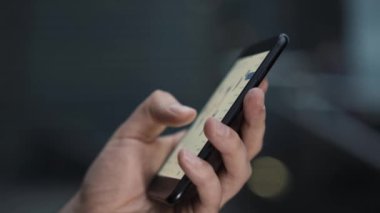 İşadamı cep telefonu kullanıyor, borsa verilerini kontrol ediyor