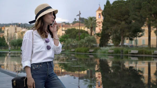 Eski güzel binaların telefon geçmişine sahip şapkalı genç bir kadın.