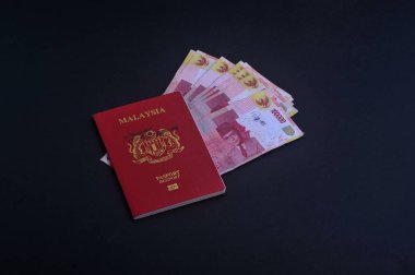 Cumhuriyeti Endonezya Rupiahı notlar koyu arka plan üzerine Malezya pasaportu ile.
