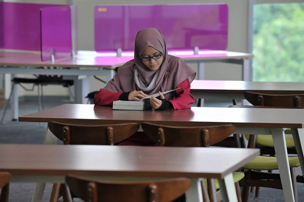 図書館で一人で勉強する美しい若いムスリム — ストック写真