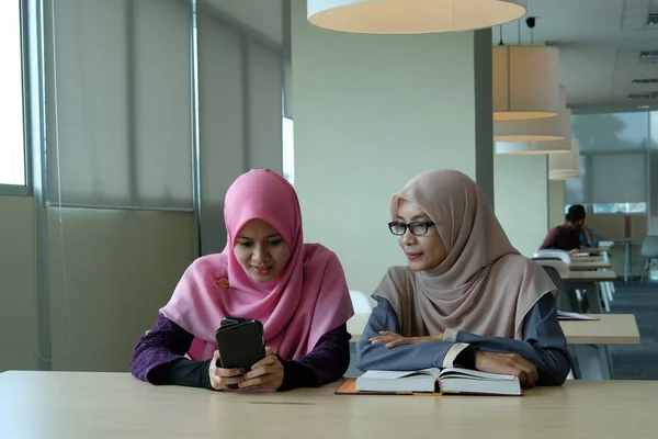Hermosas Mujeres Jóvenes Hijab Mirando Teléfono Inteligente Una Biblioteca —  Fotos de Stock