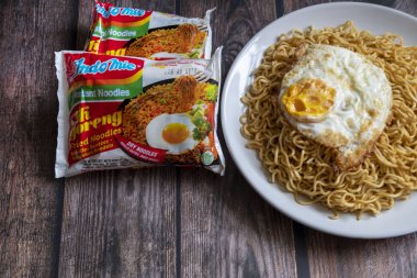 Paris, Fransa - 24 Nisan 2019: Indomie Fried Noodle 24 Nisan 2019 'da Paris' te tahta bir masanın üstünde. Indomie, Endonezyalı bir firma olan Indofood tarafından üretilen bir hazır eriştedir..