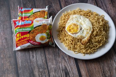 Paris, Fransa - 24 Nisan 2019: Indomie Fried Noodle 24 Nisan 2019 'da Paris' te tahta bir masanın üstünde. Indomie, Endonezyalı bir firma olan Indofood tarafından üretilen bir hazır eriştedir..