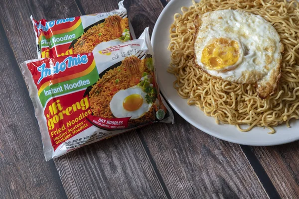 PARIS, FRANCE - APRIL 24 2019: Indomie Fried Noodle on top of a wooden table in Paris, April 24, 2019. Indomie is a brand of instant noodle produced by an Indonesian company; known as Indofood. Stock Image