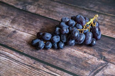 Tahta masanın üstünde tohumsuz kırmızı üzüm..