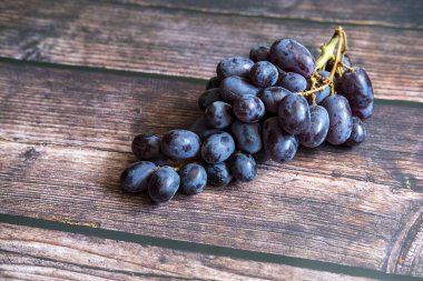 Tahta masanın üstünde tohumsuz kırmızı üzüm..