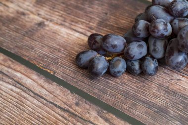 Tahta masanın üstünde tohumsuz kırmızı üzüm..